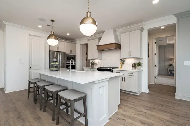 Oyster kitchen with a wood hood surround and quartz island
