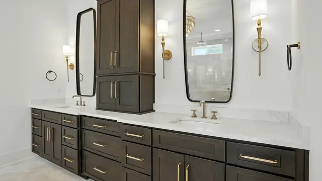 Walnut double vanity with a center storage tower