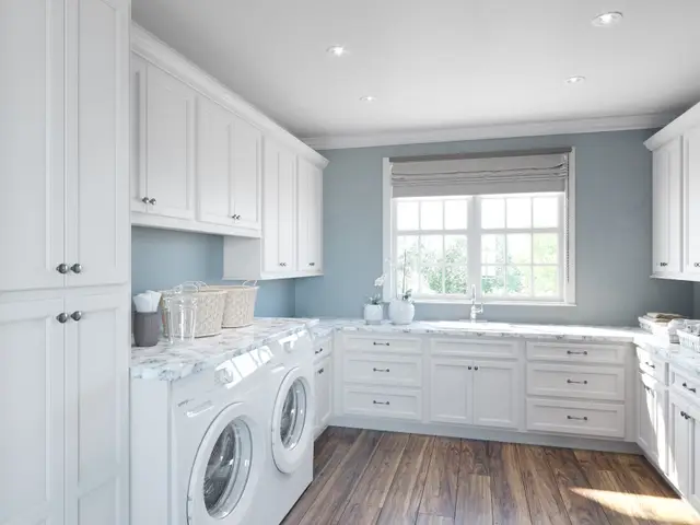 Timberland White laundry cabinetry with a folding counter and tall storage